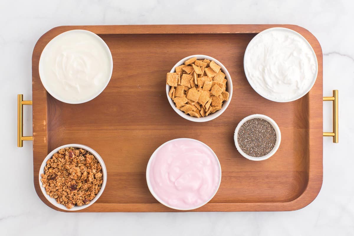 Toppings and yogurt in small bowls.