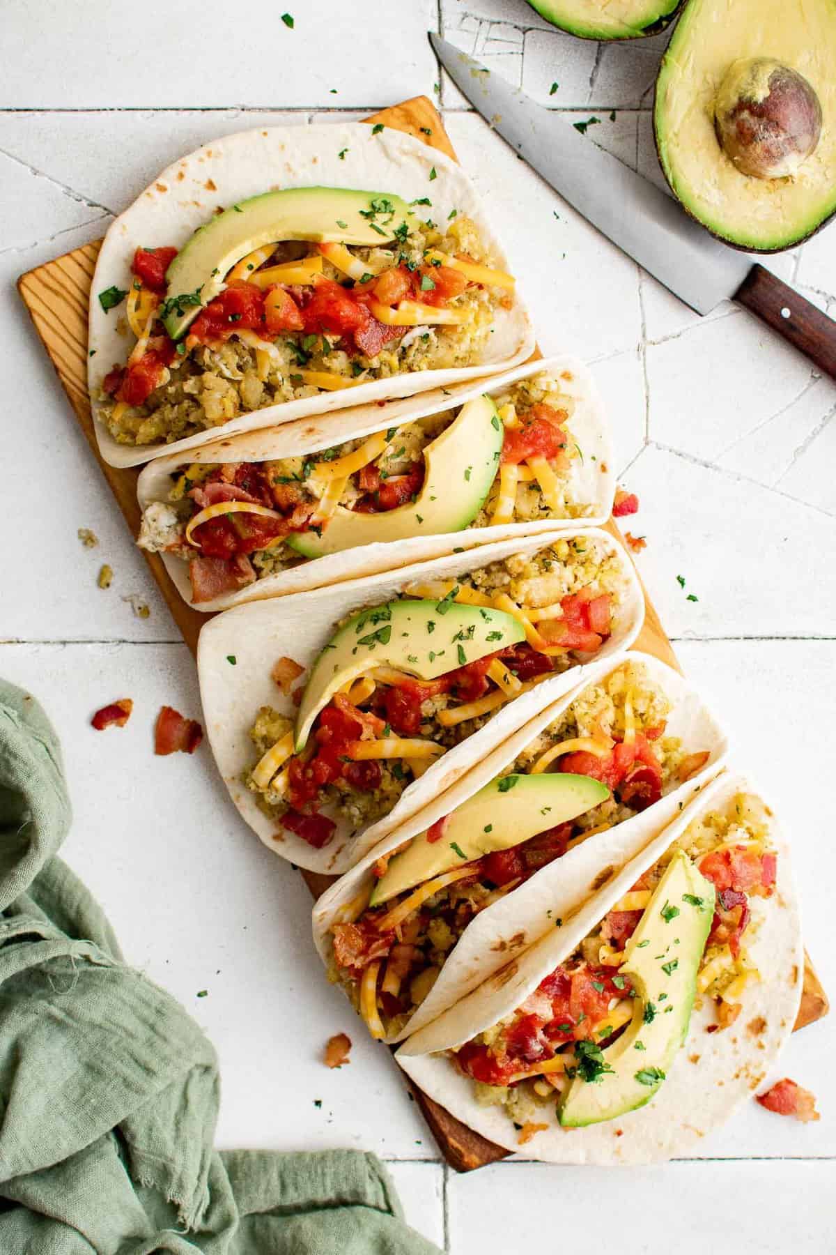 Breakfast tacos lined up on a serving platter.