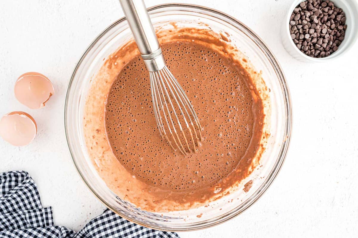 Chocolate pancake batter with a whisk.