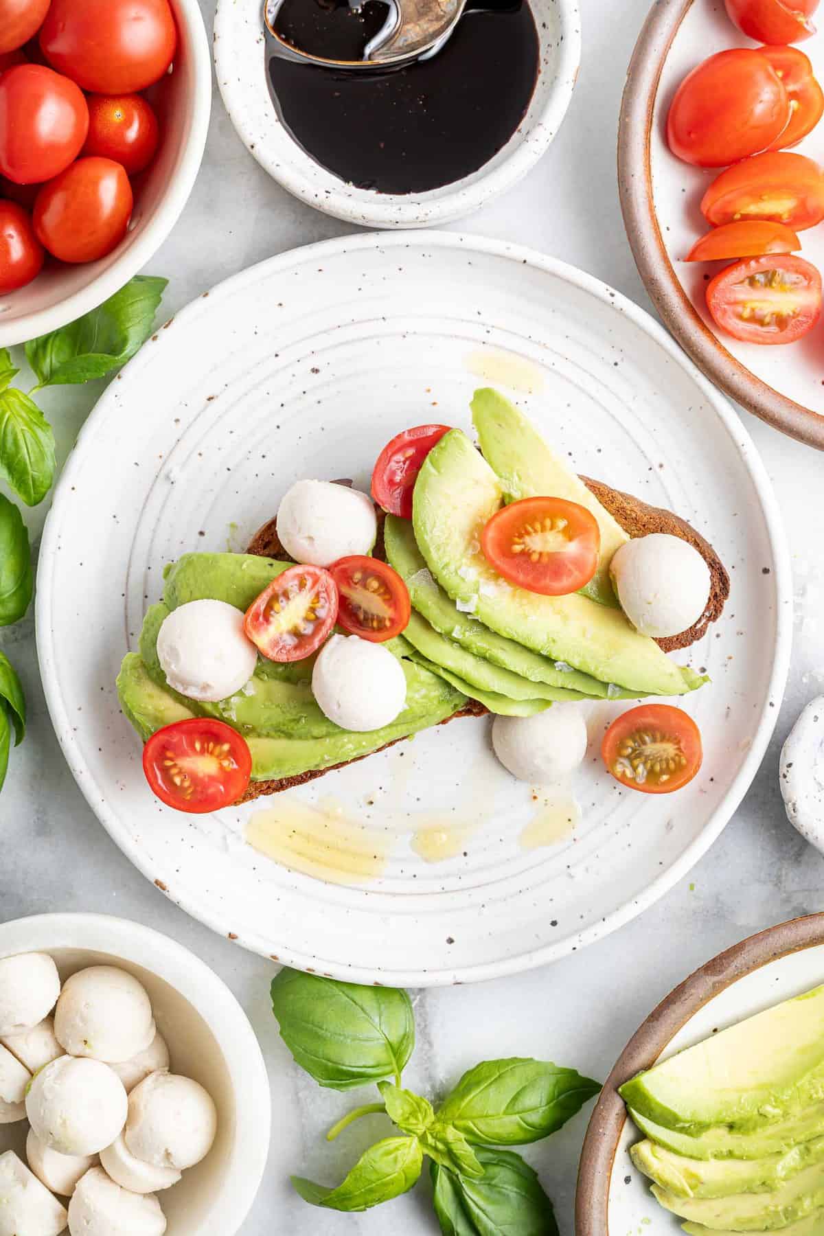 Avocado toast topped with fresh mozzarella and fresh tomatoes.