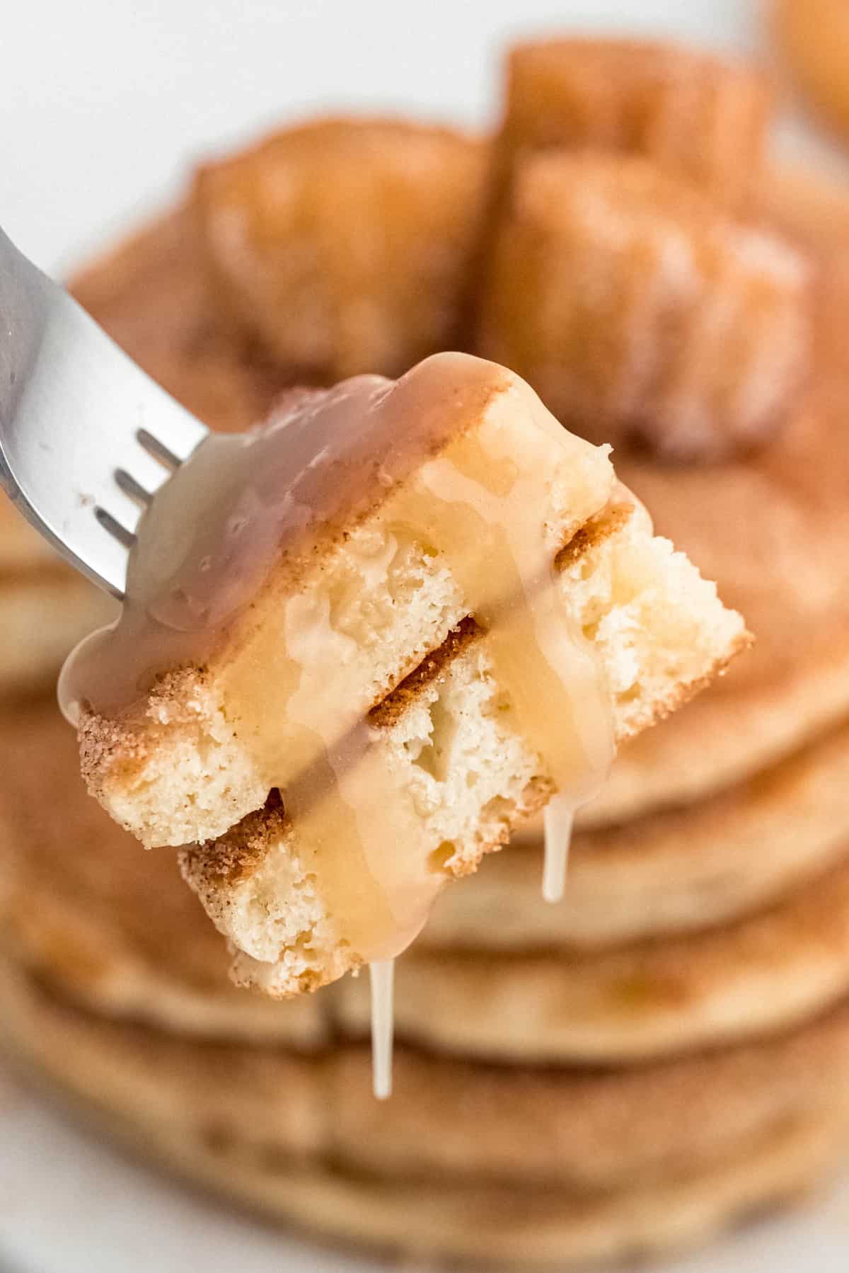 Pancakes with cinnamon sugar and syrup on a fork.