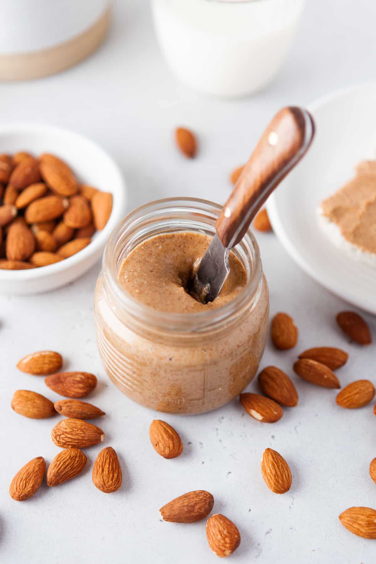 Homemade almond butter in a jar with a spreader.