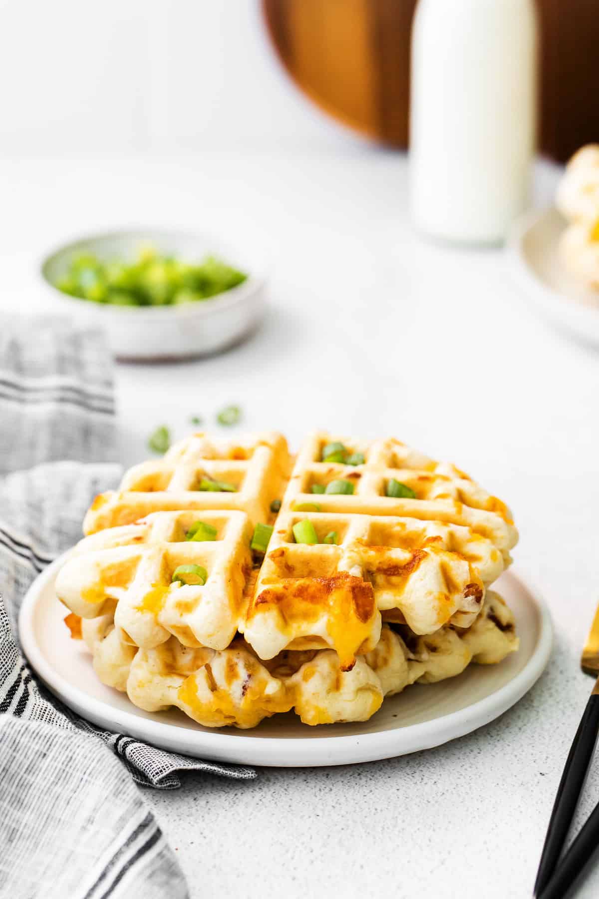 Two savory waffles stacked on a plate.