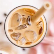 Overhead view of iced caramel coffee with a brown straw.