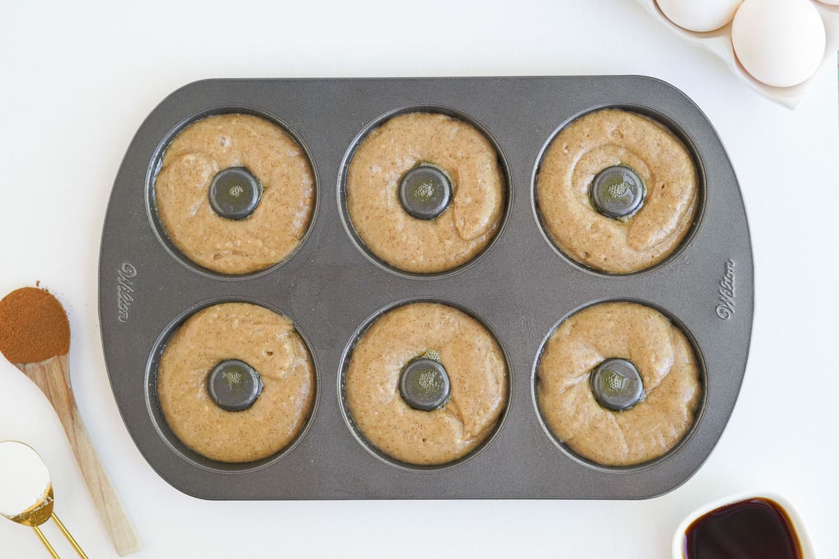 Unbaked donuts in a six well donut pan.
