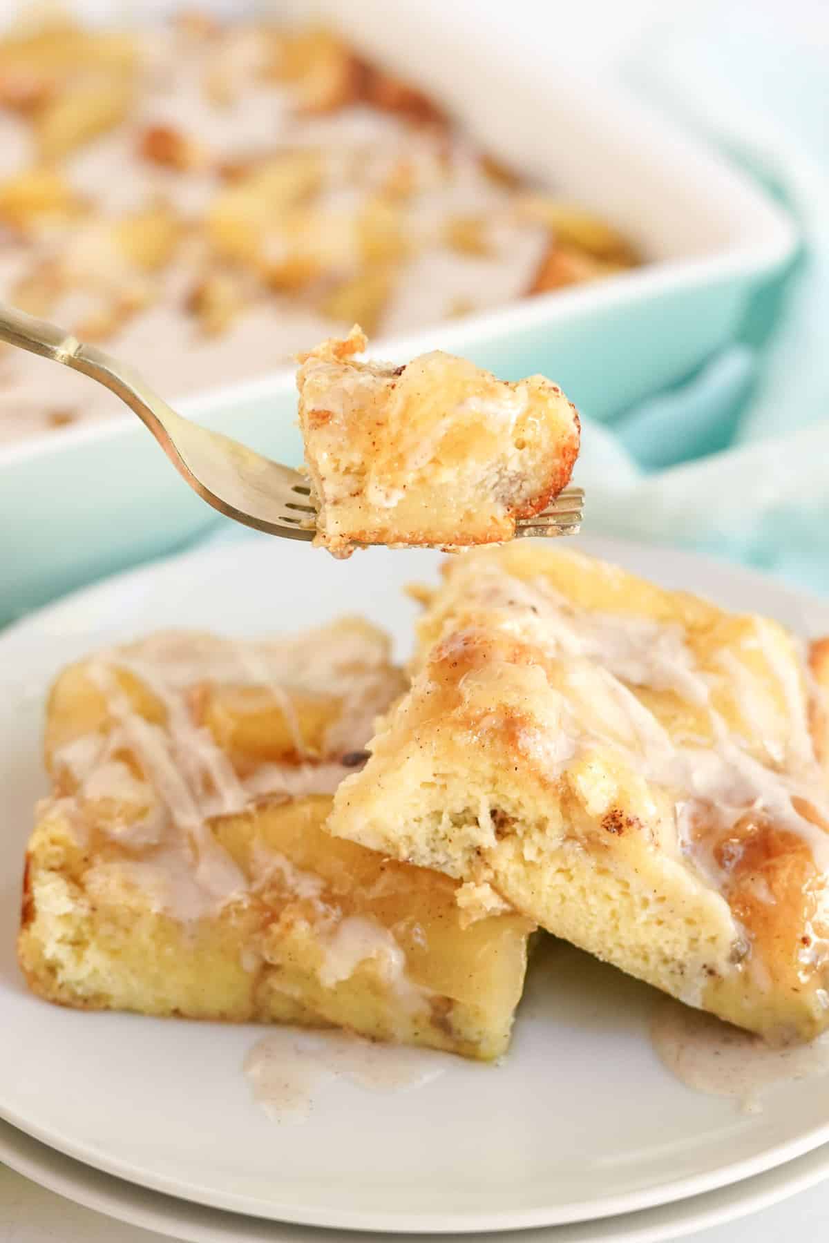 French toast casserole with apples on a fork, more in background.