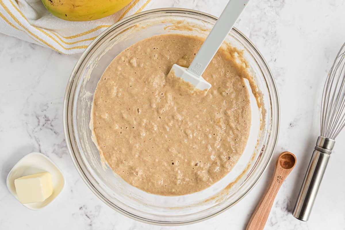 Pancake batter in a clear glass mixing bowl.