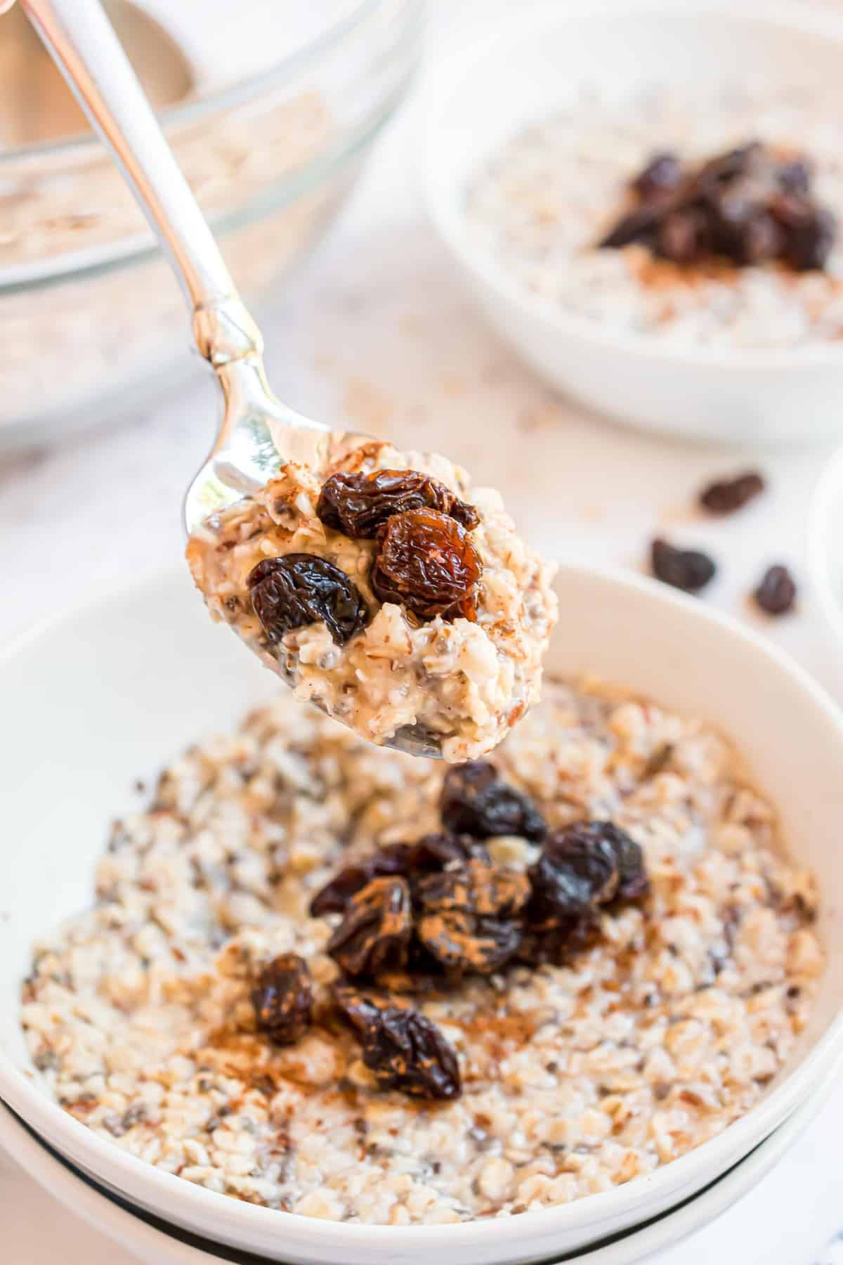 Oatmeal on a spoon with raisins. 