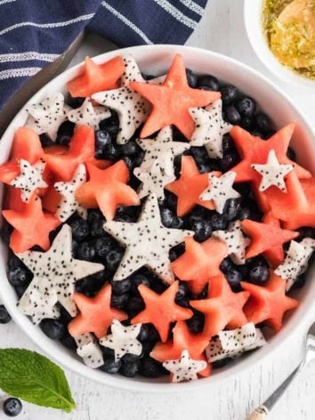 Fruit salad with red, white, and blue fruit cut into star shapes.