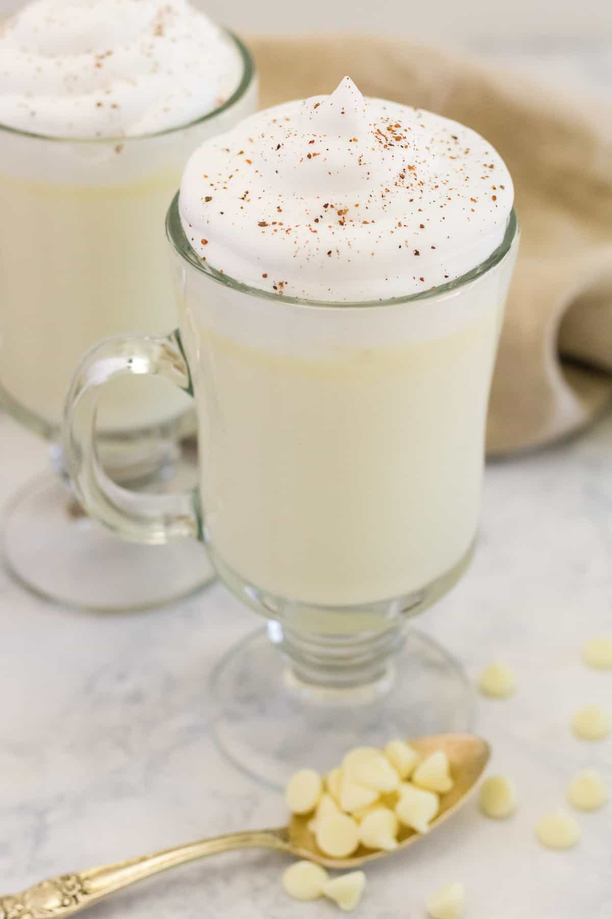 White hot chocolate in a clear glass mug.