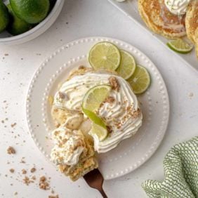 Overhead view of pancakes topped with whipped cream, lime, and graham crumbles.