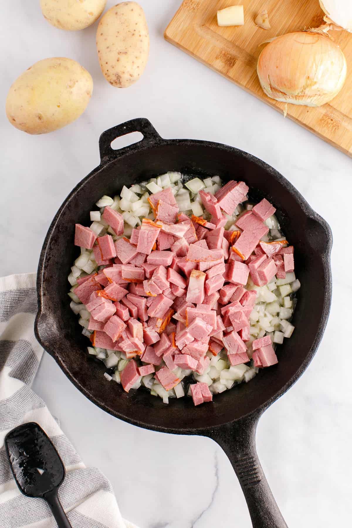 Corned beef added to skillet.