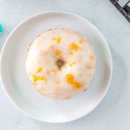 Overhead view of a glazed donut with lemon zest.