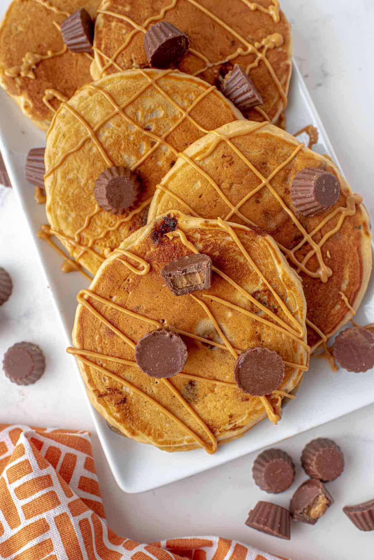 Reese's peanut butter cup pancakes drizzled with peanut butter.