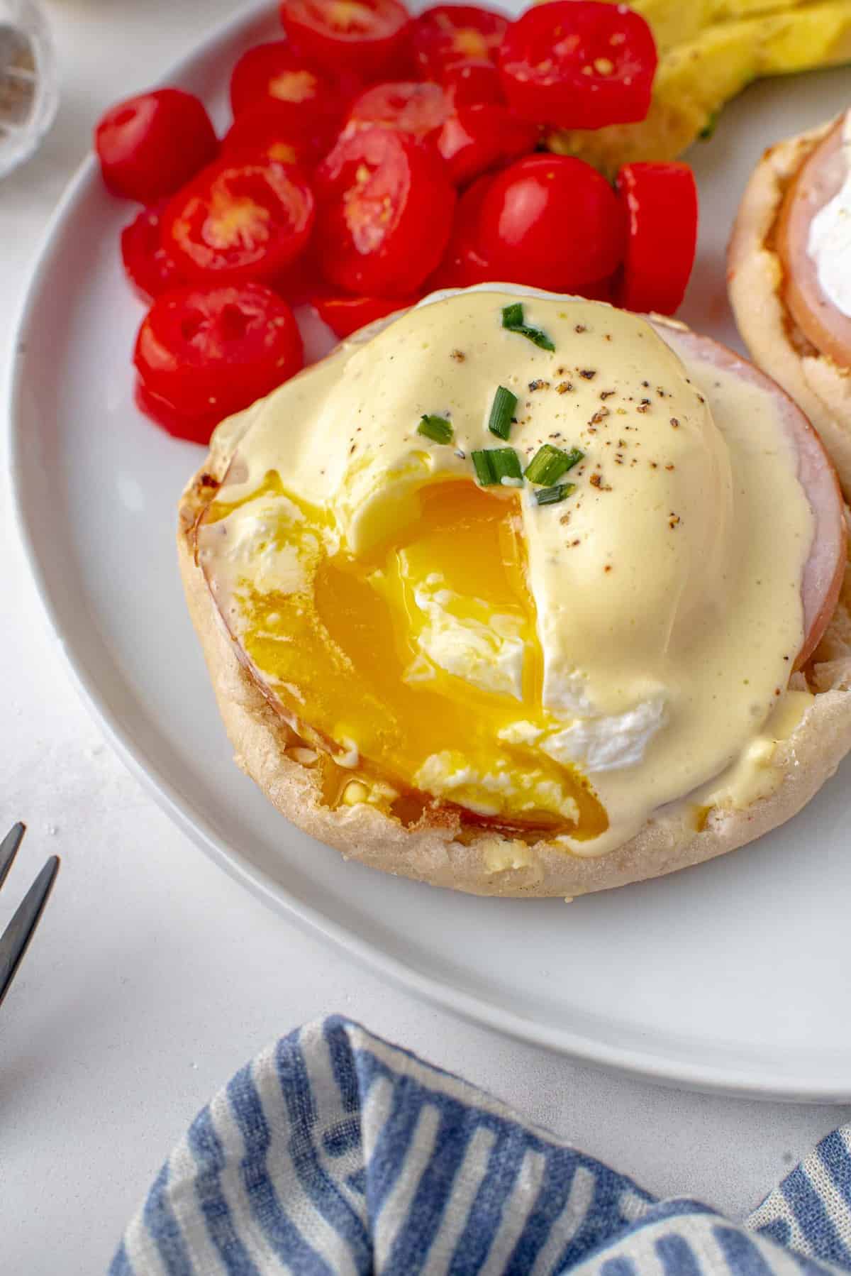 Eggs Benedict cut open to show runny yolk.