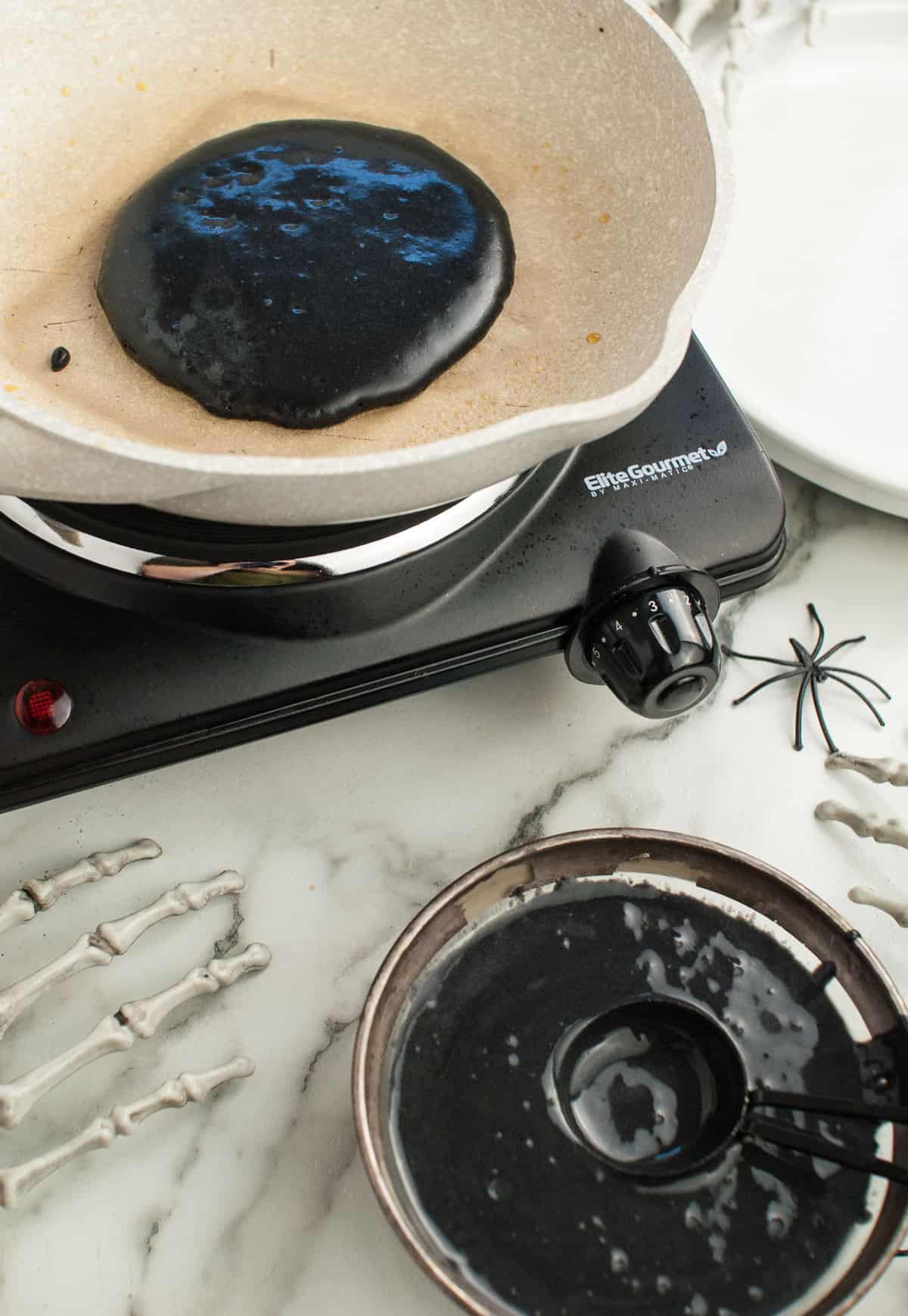 Black pancake batter in a skillet.