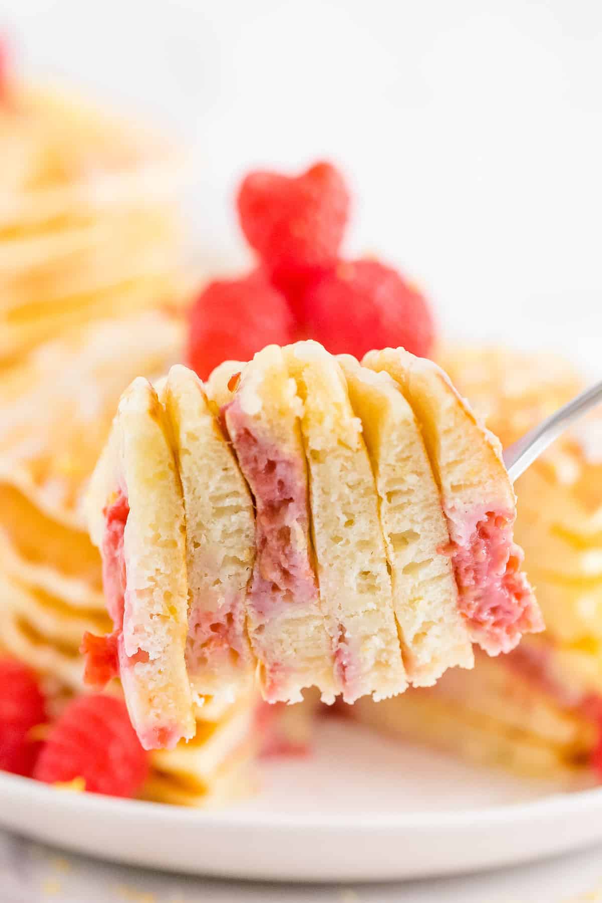 Close up of lemon raspberry pancakes on a fork.