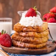 Stack of french toast stuffed with whipped cream and strawberries.