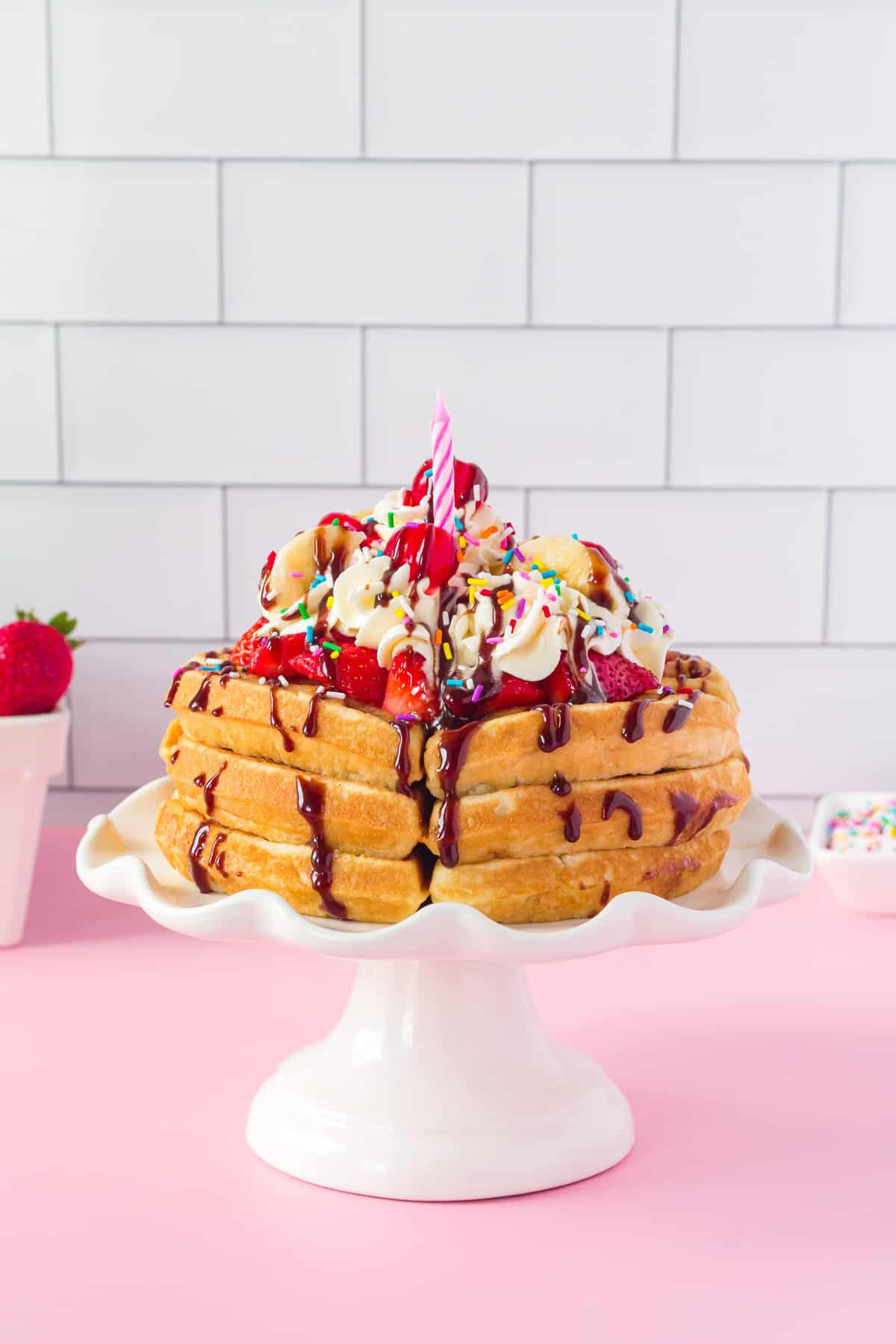 Banana split pancakes on a cake stand.