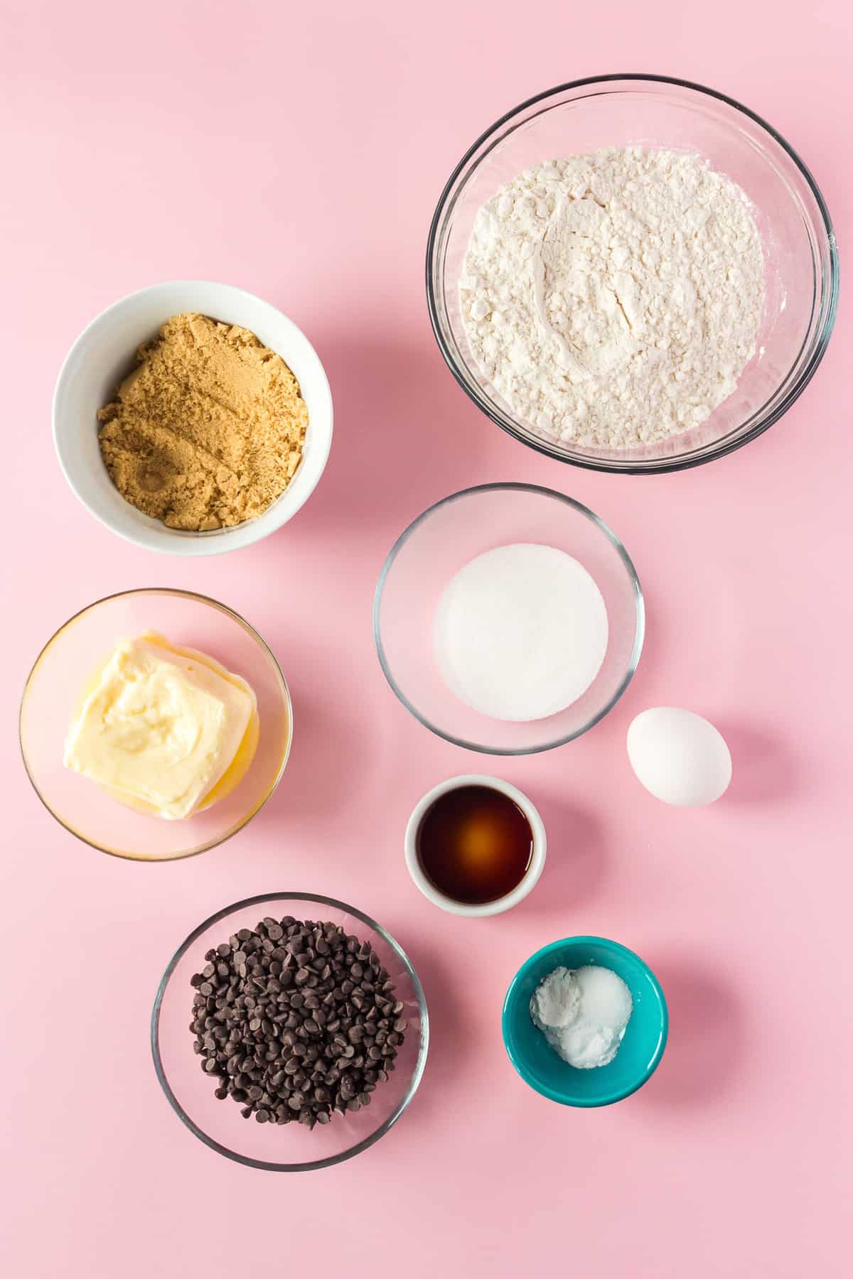 Overhead view of ingredients needed in separate bowls, pink background.