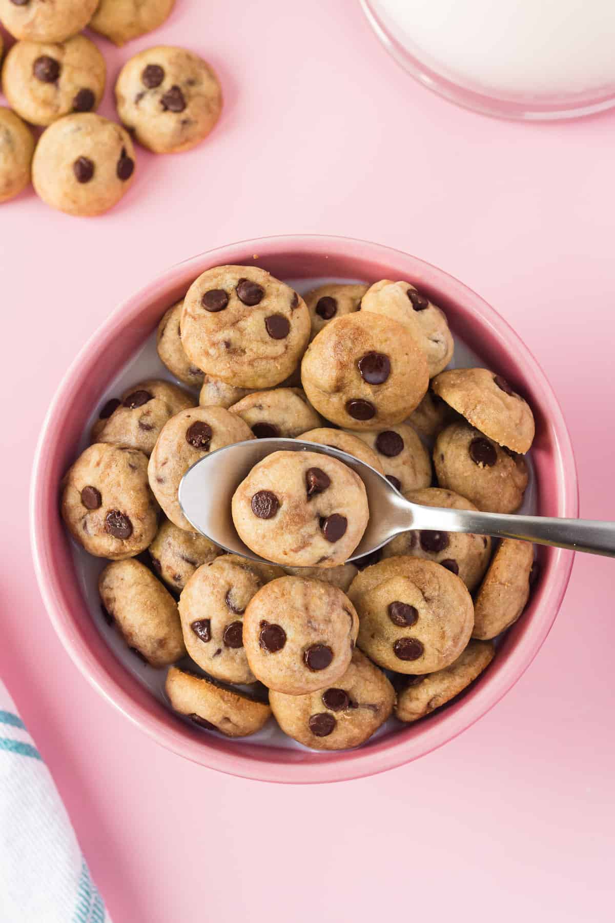 Overhead view of a bowl of homemade cookie cereal against pink background.