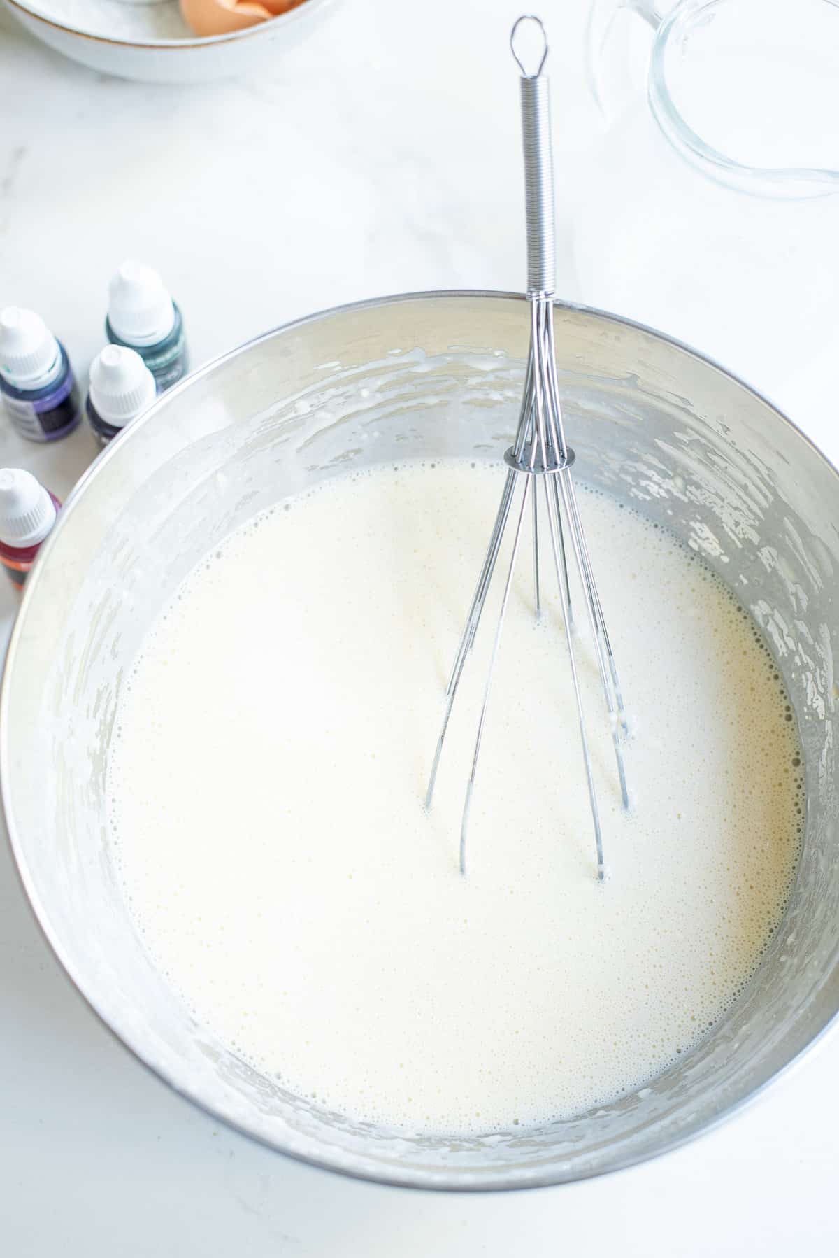 Pancake batter in a bowl with a whisk.