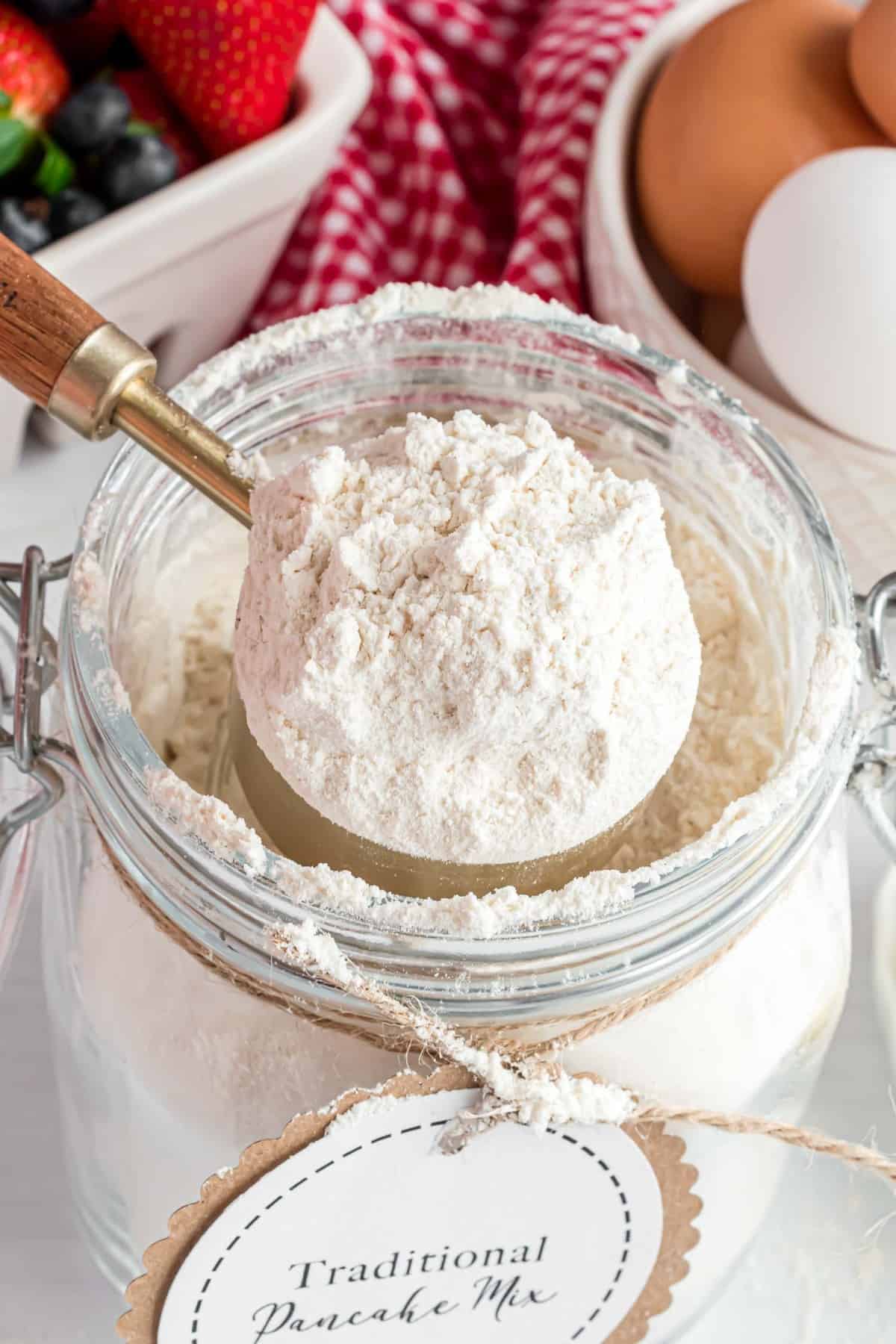 Pancake mix being scooped out of a jar.