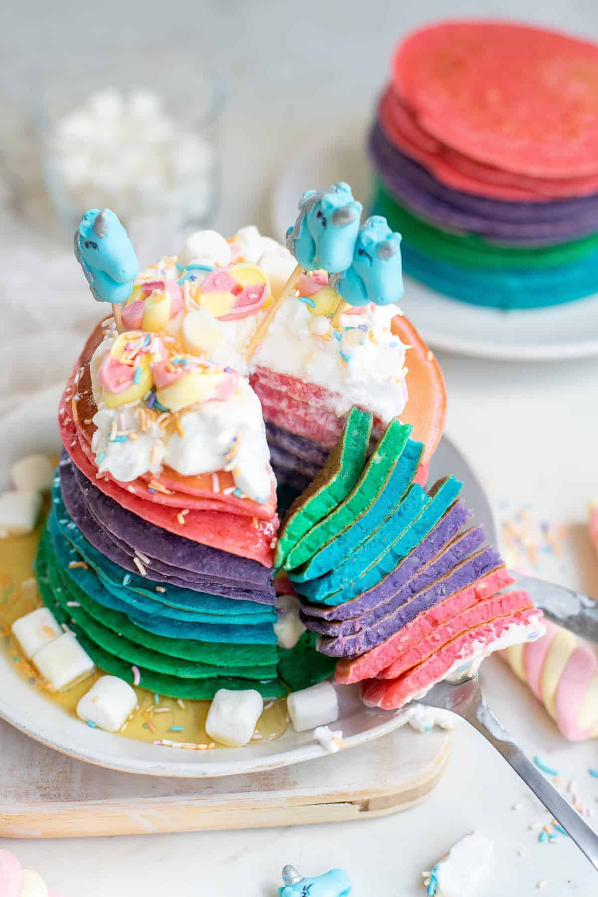 Large stack of colorful unicorn pancakes.