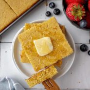 Cut square pancake topped with butter and syrup.