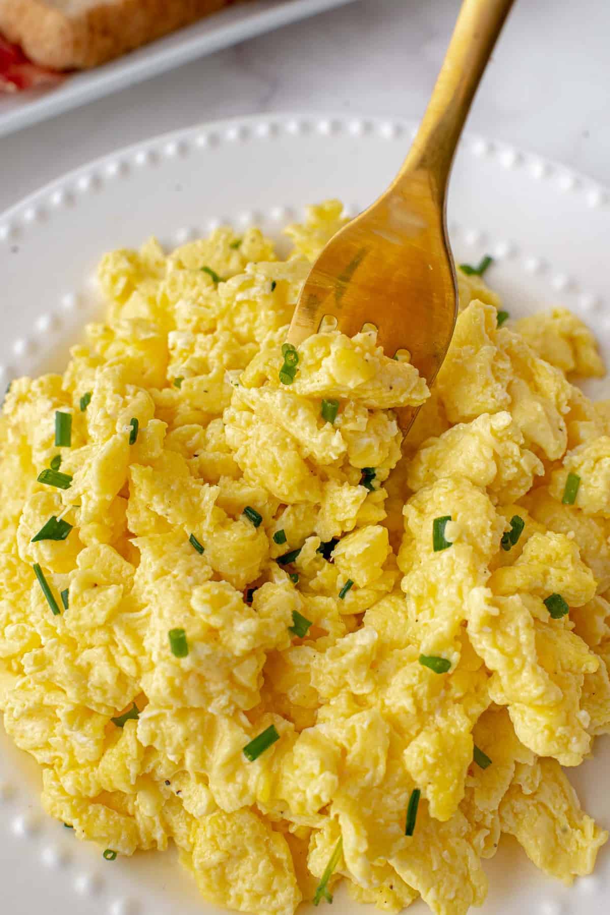 Scrambled eggs in a large white bowl.