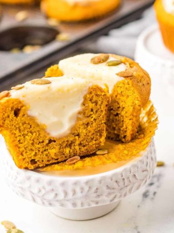 Pumpkin muffin split open to show cream cheese filling.