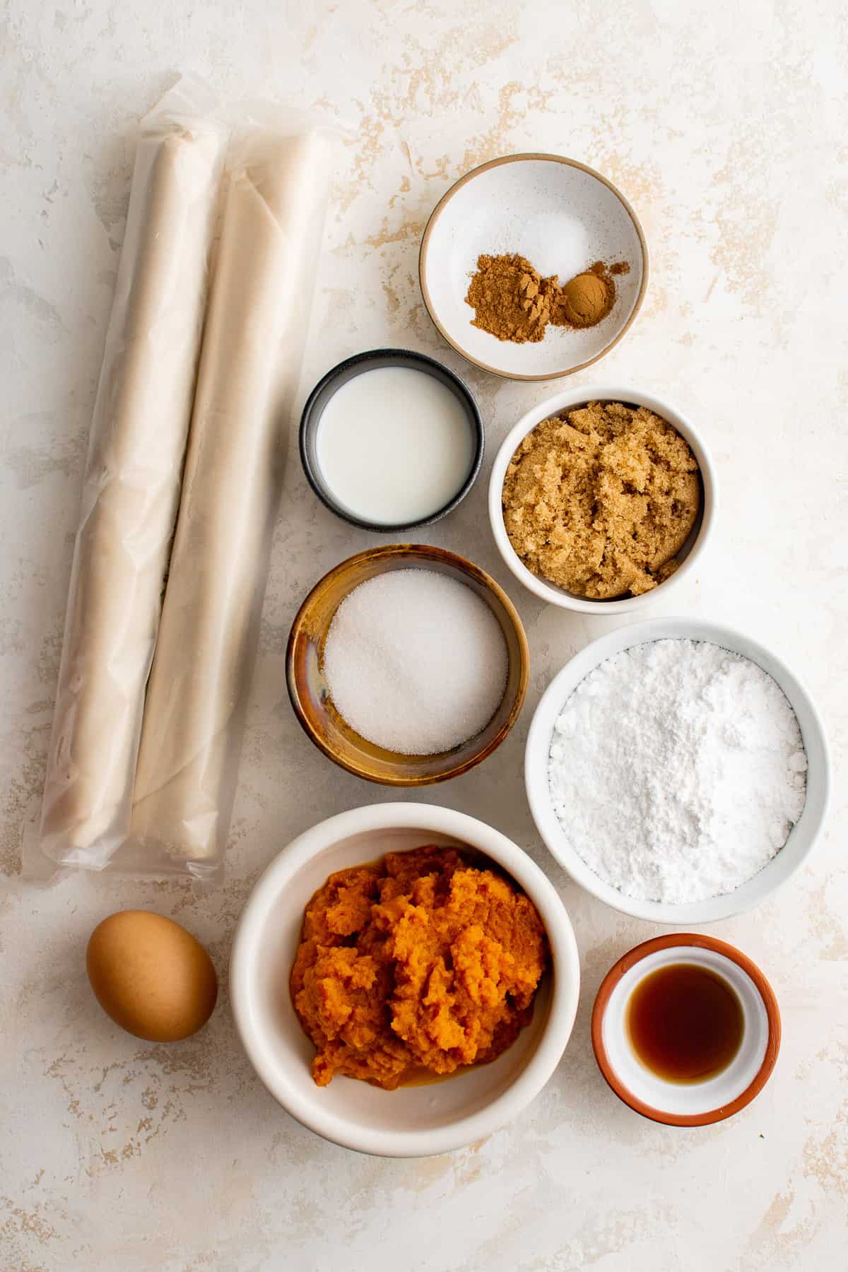 Overhead view of ingredients needed for recipe including pie crusts and pumpkin puree.