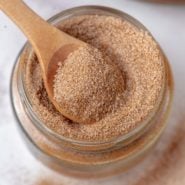 Cinnamon sugar in a small jar with little wooden spoon.