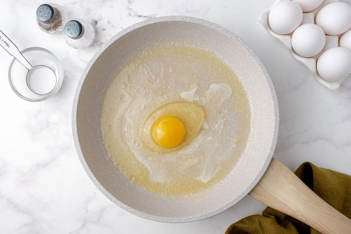 Uncooked egg in frying pan.