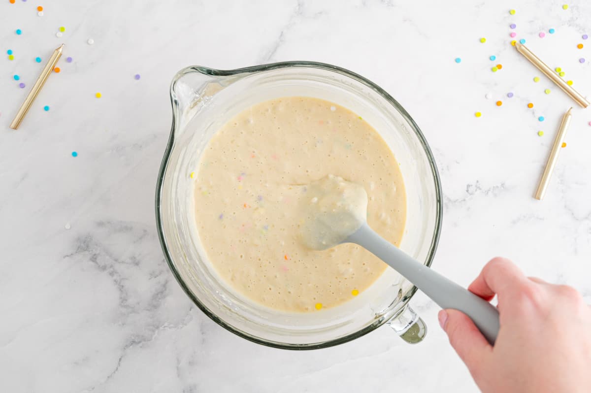 Pancake batter with sprinkles in a mixing bowl.