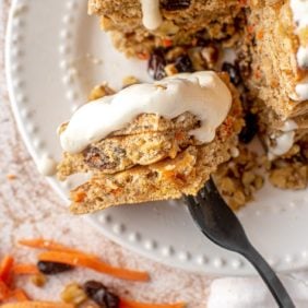 Carrot cake pancakes cut to show texture, topped with cream cheese glaze.
