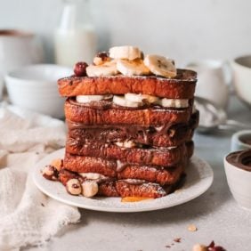 Tall stack of french toast layered with Nutella and bananas.