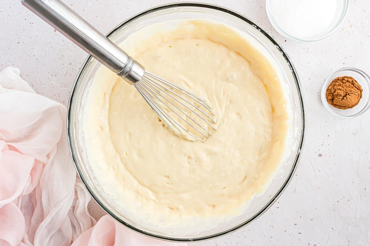 Pancake batter in a bowl with a whisk.