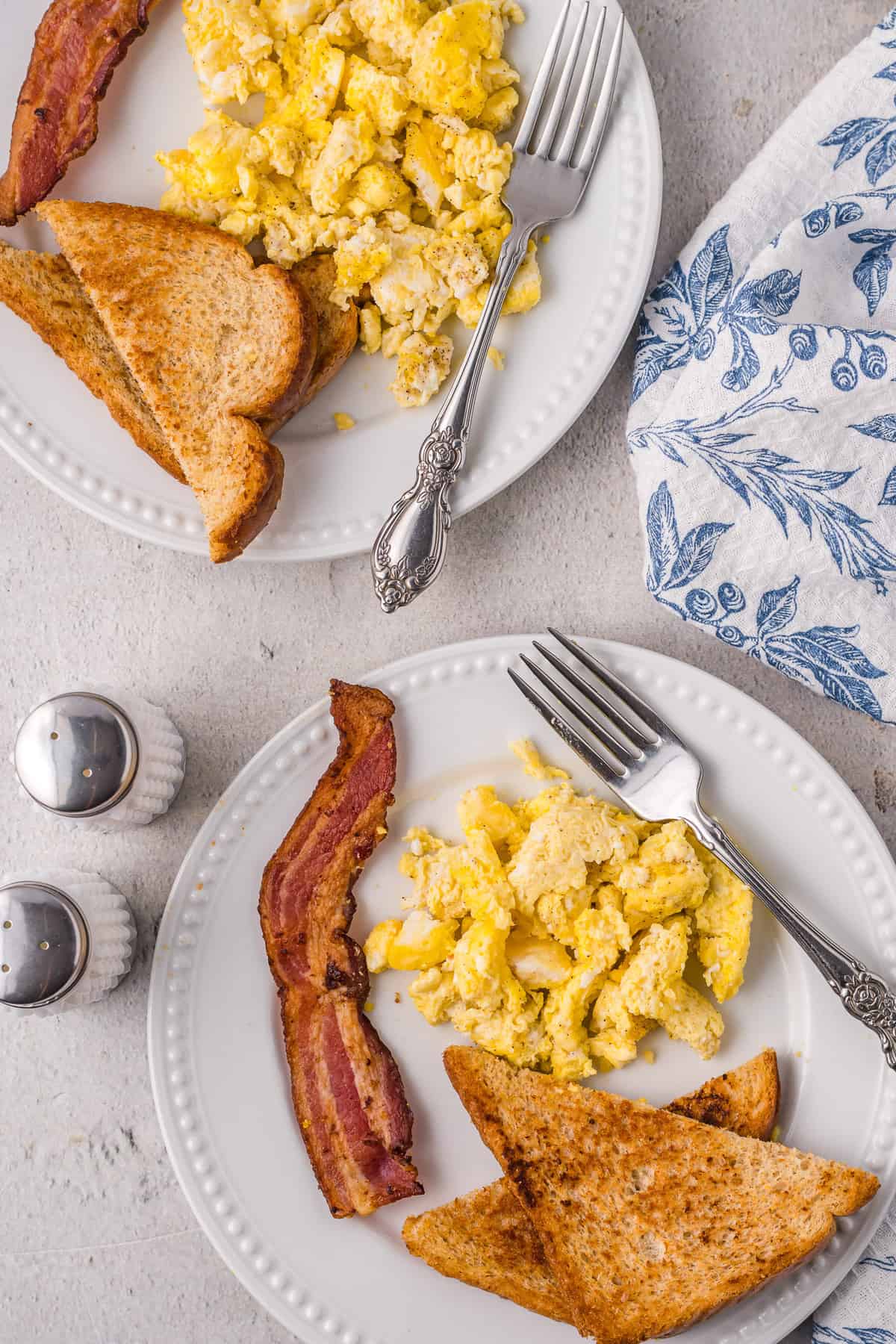 Microwave scrambled eggs on a plate with bacon and toast.