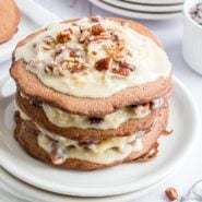 Stack of German chocolate pancakes with filling between each layer and pecans on top.
