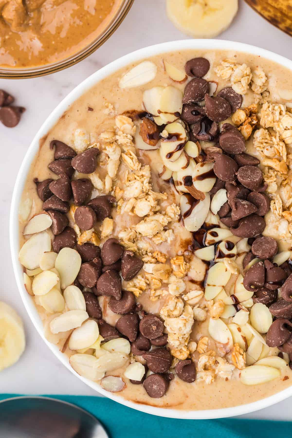 Peanut butter banana smoothie bowl with a variety of toppings.