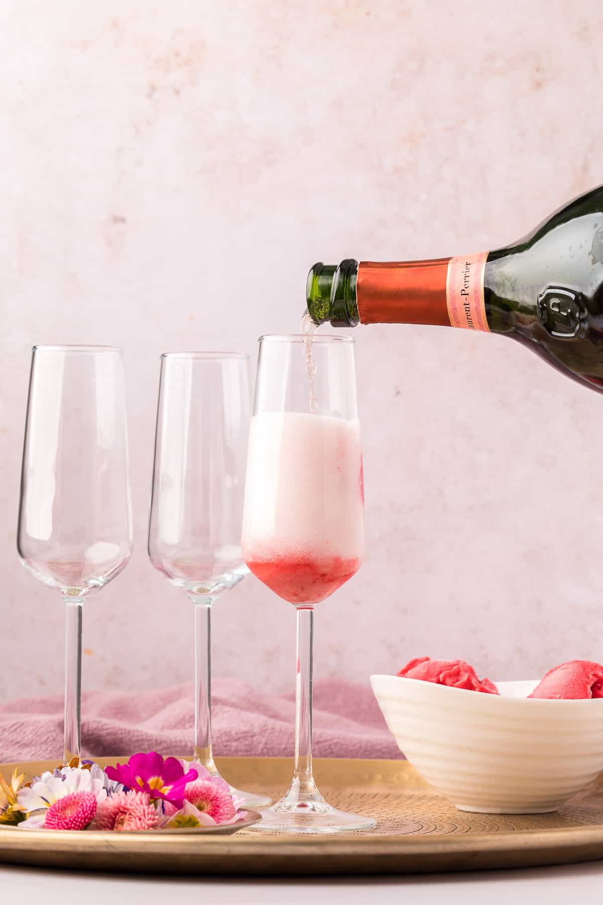 Champagne being poured into a glass with sorbet.