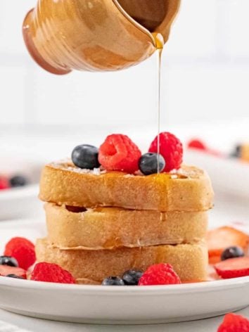Stack of vegan french toast with syrup being poured on it.