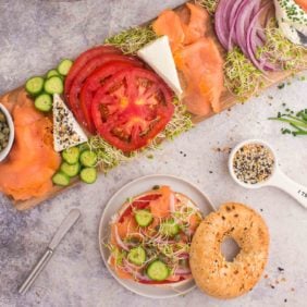 Lox Bagel board with an assembled bagel next to it.
