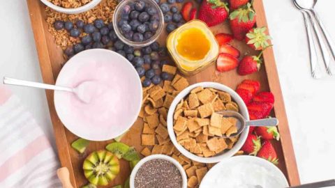 Yogurt parfait board with toppings and fruit.