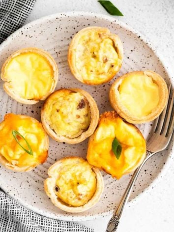 Three varieties of mini quiches on a small plate.