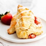 Two strawberry scones on a round white plate.