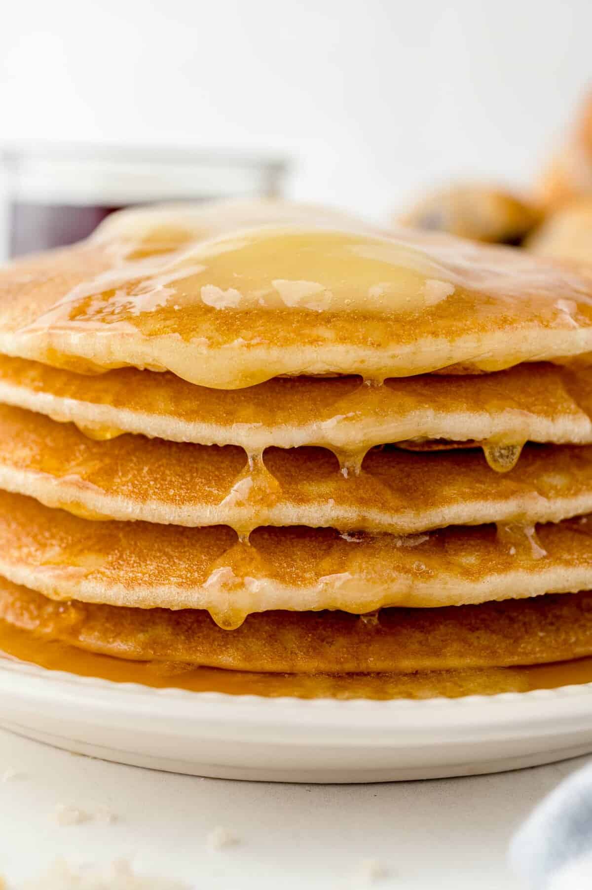 Maple butter dripping down a stack of pancakes.
