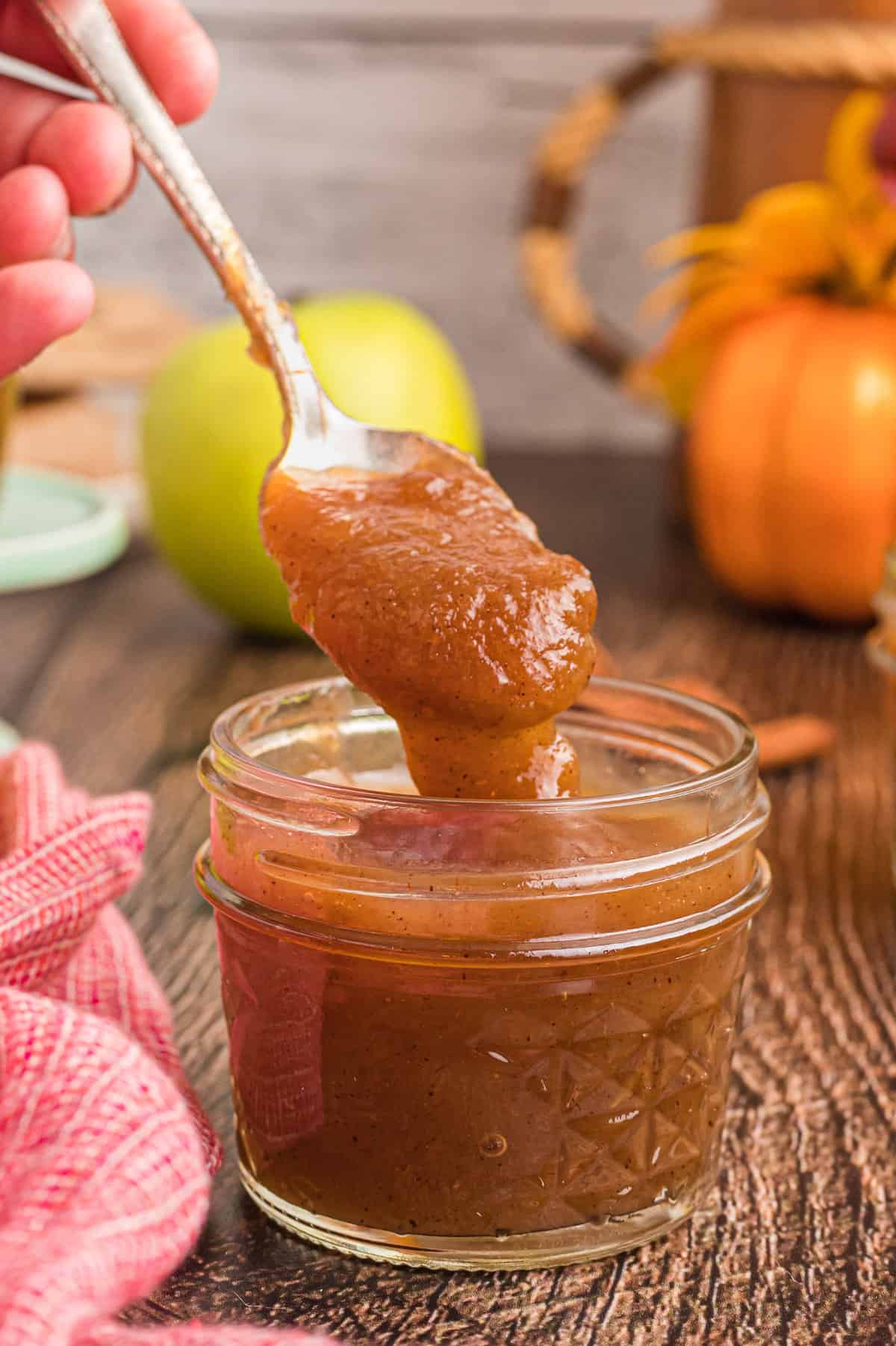 Apple butter in a small jar with spoon.