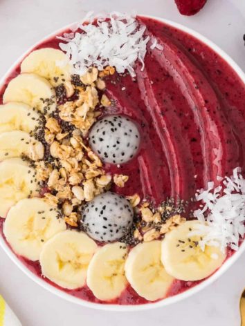 Berry smoothie bowl with assorted toppings.